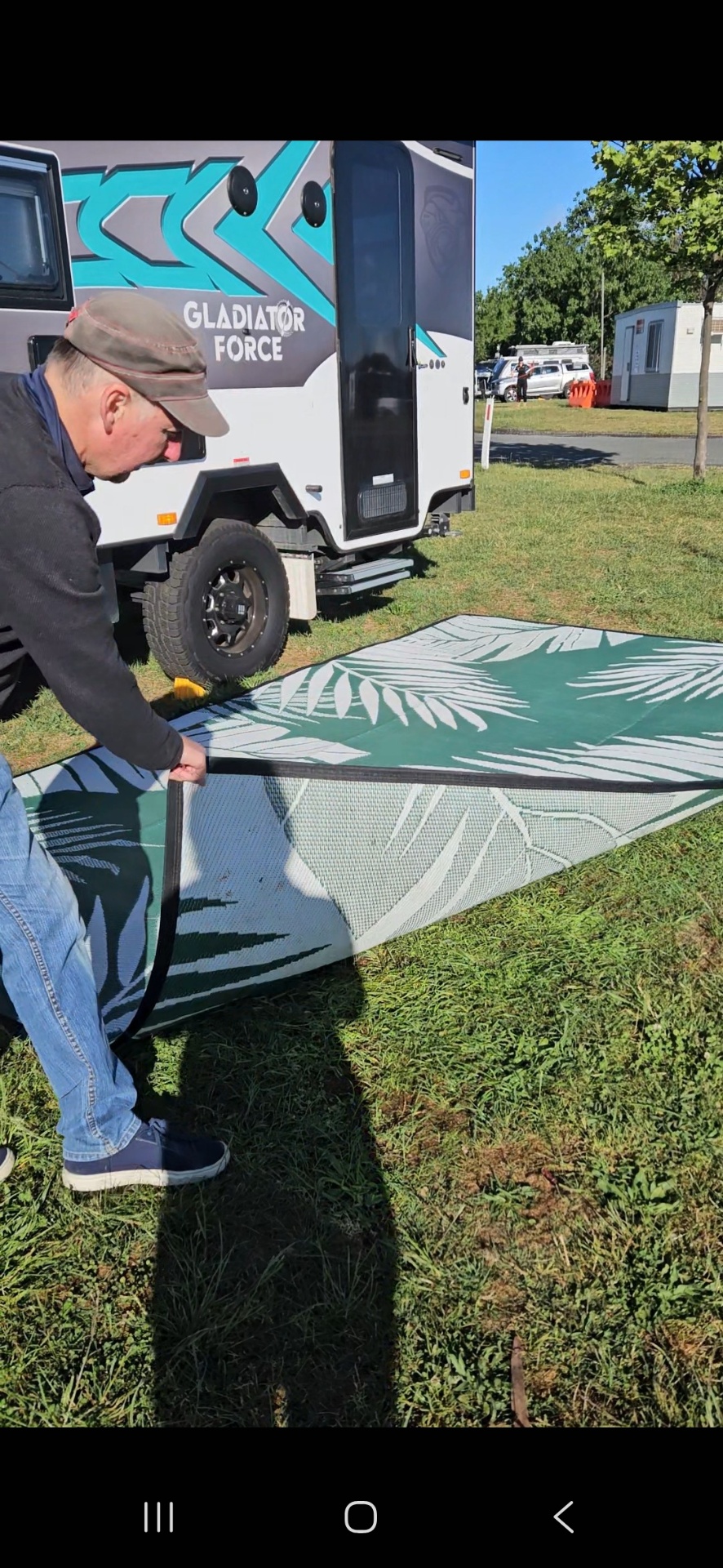 Green Mooving Mat laid over lawn grass, showing the open weave that lets air through